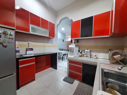 a large kitchen with red cabinets and a sink at DN Homestay Kuala Terengganu - Feel At Home in Kuala Terengganu