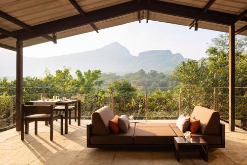 a living room with a couch and a view of mountains at Dharana at Shillim All Inclusive Luxury Wellness Retreat in Lonavala