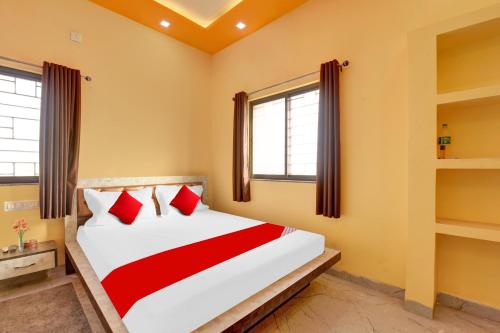 a bedroom with a large bed with red pillows at Hotel O The Heart Residency in Rāmgarh