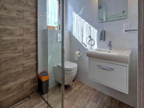 a bathroom with a toilet and a sink and a shower at Holiday Home Wi niowa with Pool and Nature in Iwierzyce