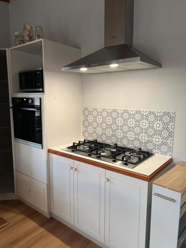 a kitchen with white cabinets and a stove top oven at 3 bdm Central Albany House in Albany