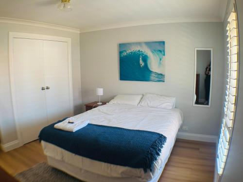 a bedroom with a large bed with a blue blanket at 3 bdm Central Albany House in Albany