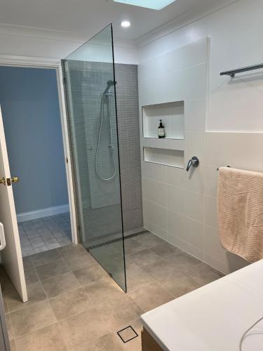 a bathroom with a shower with a glass shower stall at 3 bdm Central Albany House in Albany