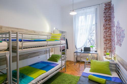 a room with two bunk beds and a desk at Friends Hostel & Apartments in Budapest