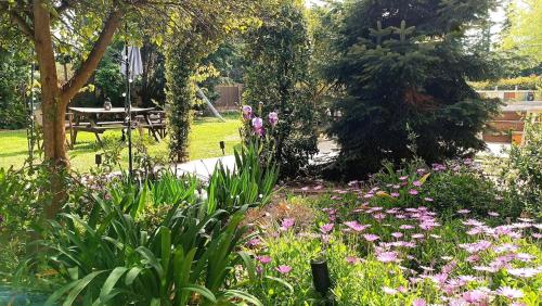 a garden with flowers and a picnic table in a park at ΒΑΜΒΟΟ nest by the sea in Pálioura