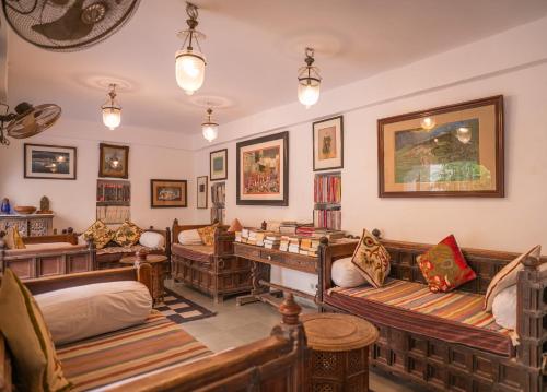 a room with several couches and a desk at Kankarwa Haveli in Udaipur