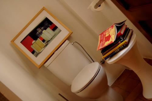 Una habitación con un inodoro con un montón de libros. en Casa Aldomar, en Xàtiva