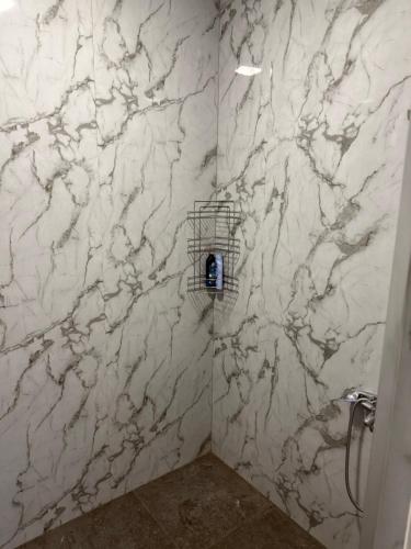 a bathroom with white marble walls and a shower at Дом для гостей in Pʼarakʼar