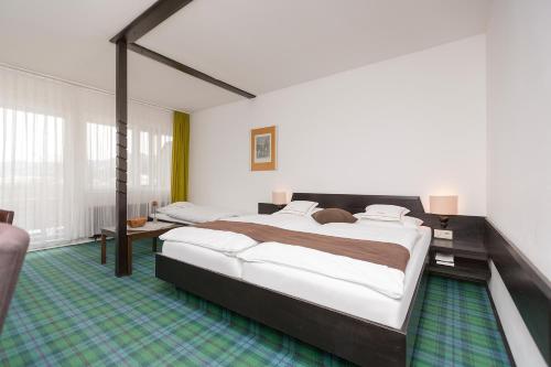 a large bedroom with two beds in a room at Hotel Alpenhof Postillion in Kochel