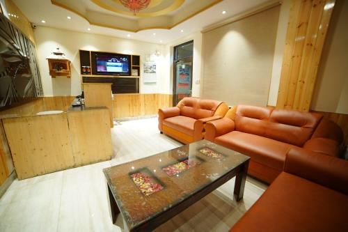 a living room with two leather couches and a table at The Royal Vista in Shimla