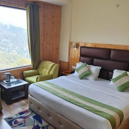 a bedroom with a bed and a chair and a window at The Royal Vista in Shimla