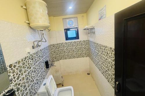 a bathroom with a toilet and a sink and a window at The Royal Vista in Shimla