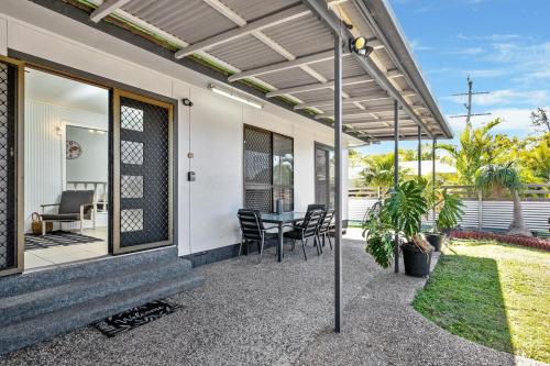 a patio of a home with a table and chairs at Beach vibes in Cooee Bay with high-speed internet in Yeppoon