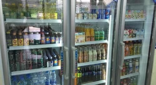 a refrigerator filled with lots of different types of drinks at Kulwadee Hotel in Si Sa Ket