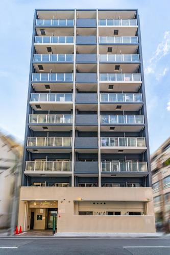 a tall building with balconies on the side of it at Apartment Hotel 11 Namba Minami in Osaka