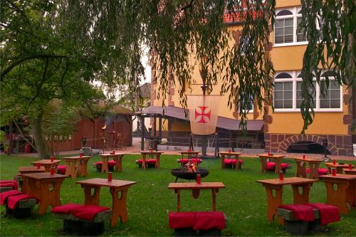 a group of picnic tables in the grass in front of a building at Ostsee-Rittergut-Rügen mit BinzHotel & OrdensKapelle & RomantikGut in Binz