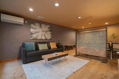 a living room with a couch and a large screen at Green House 九条 in Osaka