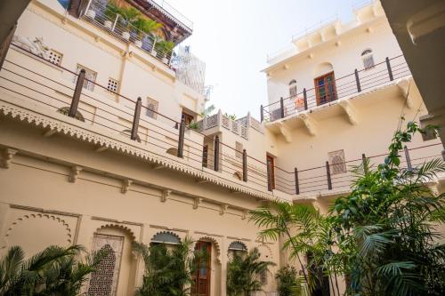 an external view of a building with balconies and trees at Kankarwa Haveli in Udaipur