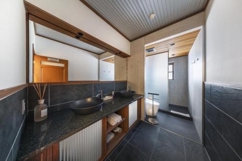 a bathroom with two sinks and a mirror at Powderhouse by The Hakuba Collection in Hakuba