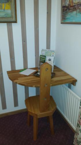 a wooden table with a chair and a laptop on it at Tallhöjden Hotel & Cottage Lodge in Simlångsdalen