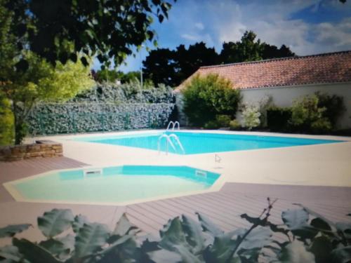 una piscina en un patio con una casa en joli appartement bord de mer, en Pornic