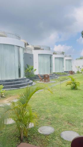 a group of white buildings with a grass yard at Pinggan Cliff in Baturaja