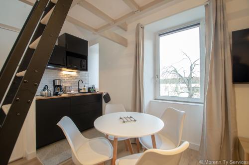 une cuisine et une salle à manger avec une table et des chaises dans l'établissement Studio design avec mezzanine - Ty ar Joly, à Rennes