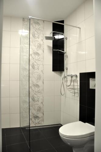 a bathroom with a toilet and a glass shower at Apartamenty Przy Starówce in Zielona Góra