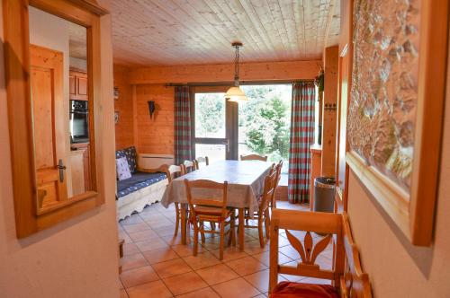 une cuisine et une salle à manger avec une table et des chaises dans l'établissement Appartement vue sur les pistes, à Valloire