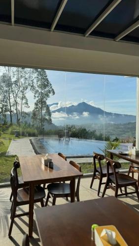 a patio with a table and chairs and a large glass window at Pinggan Cliff in Baturaja