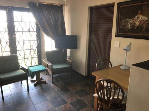 a living room with two chairs and a table and a tableablish at Haus Barbara Guest House in Bredasdorp