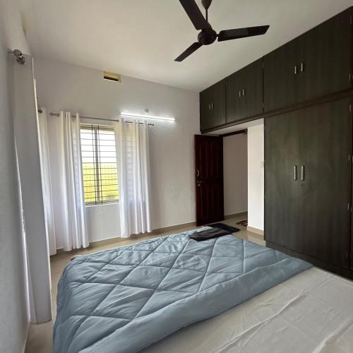 a bedroom with a large bed with a ceiling fan at Sri Krishna AC Homestay in Udupi