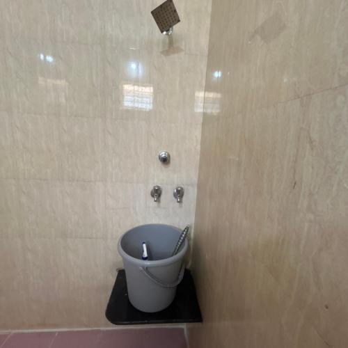 a bathroom with a toilet in the corner of a room at Sri Krishna AC Homestay in Udupi