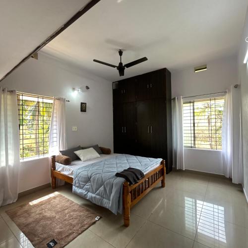 a bedroom with a bed and a ceiling fan at Sri Krishna AC Homestay in Udupi