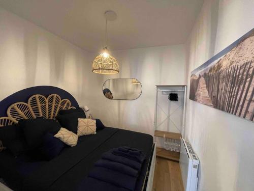 - une chambre avec un lit noir et un miroir dans l'établissement Cosy cottage by Alice Bord 2 mer, à La Ciotat