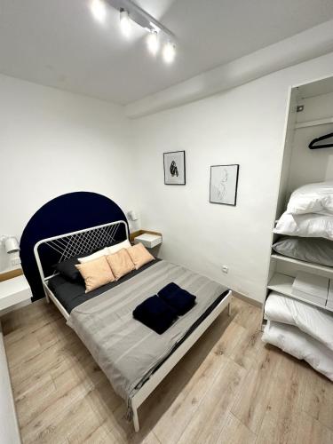 une chambre avec un lit avec une tête de lit bleue dans l'établissement Cosy cottage by Alice Bord 2 mer, à La Ciotat