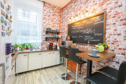 a kitchen with a table and chairs and a clock on the wall at Friends Hostel & Apartments in Budapest