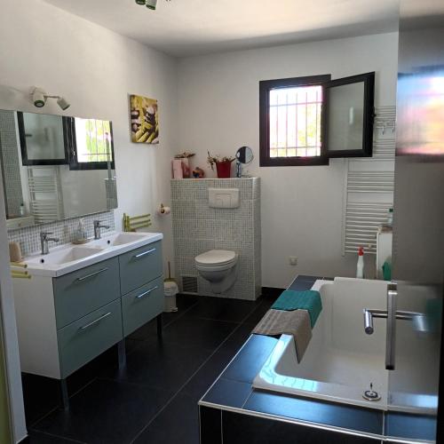 une salle de bain avec un lavabo, des toilettes et une baignoire dans l'établissement Magnifique villa, à Penta-di-Casinca