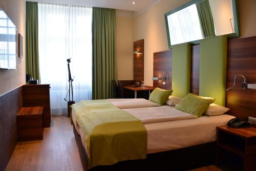 ein Schlafzimmer mit einem großen Bett mit grünen Wänden in der Unterkunft Arthotel Munich in München