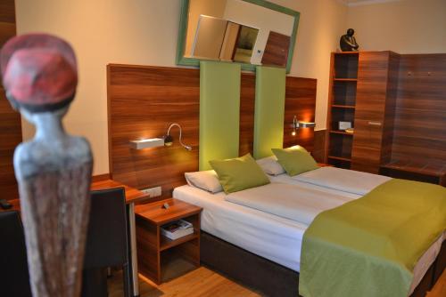 ein Schlafzimmer mit einem Bett, einer Kommode und einer Puppe in der Unterkunft Arthotel Munich in München
