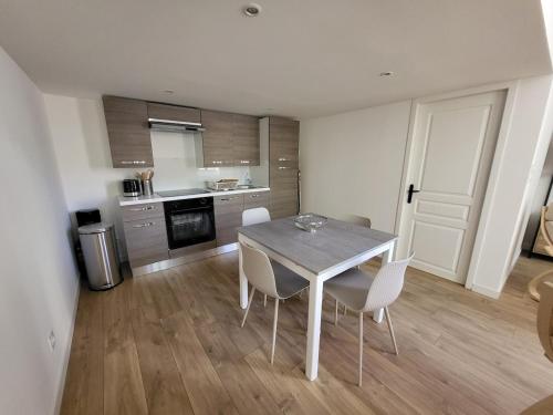 une cuisine avec une table et des chaises dans une pièce dans l'établissement Bastide La Reine Jeanne, à Eyguières