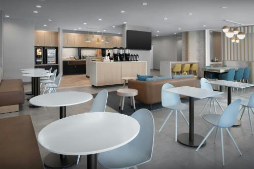a restaurant with tables and chairs and a kitchen at TownePlace Suites by Marriott Fort Myers Gulf Coast in Fort Myers
