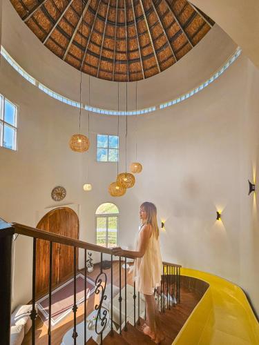 a woman standing on a railing in a room with a ceiling at Cozy Wild in Ban Kai Noi