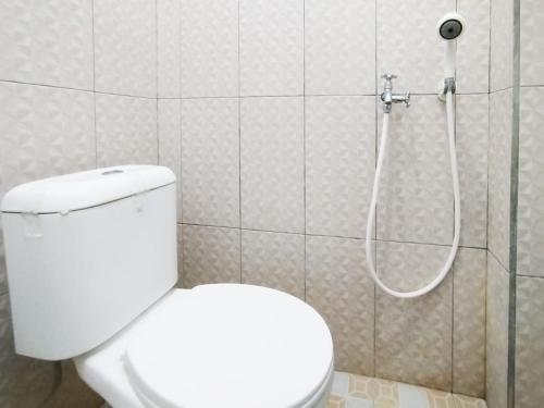 a bathroom with a toilet and a shower at Bima Homestay Baluran Mitra RedDoorz in Bajulmati