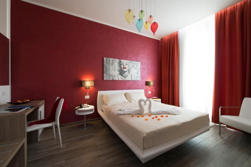a bedroom with a white bed and a red wall at Oasi Village Hotel in Milan