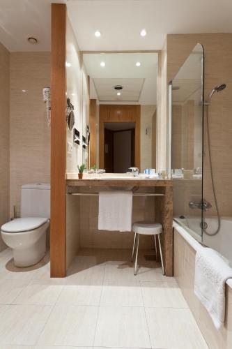 a bathroom with a toilet and a sink and a shower at Senator Parque Central in Valencia