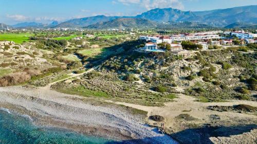 an aerial view of a village on a hill next to the ocean at Boho Bay Apartment in Akanthou