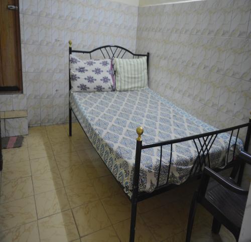 a bedroom with a bed with a blue comforter and a pillow at S M Residency in Mayiladuthurai