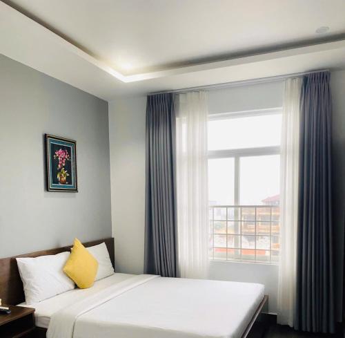 a hotel room with a bed and a window at Hue Royal Hotel in Hue