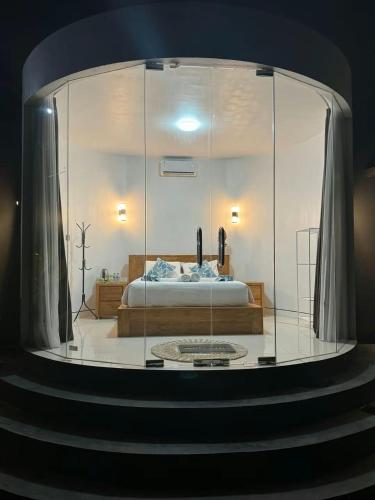 a large glass room with a bed in it at Pinggan Cliff in Baturaja
